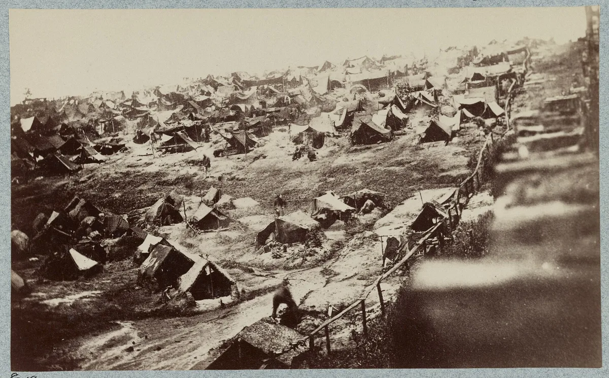 1864년 8월 앤더슨빌 수용소의 남서쪽 모습. 높은 나무 울타리 안에 천막이 빽빽하고, 울타리 안쪽을 따라 낮은 난간이 보인다